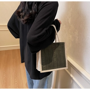 Detailed view of olive green linen tote bag showing contrasting beige trim and sturdy handles
