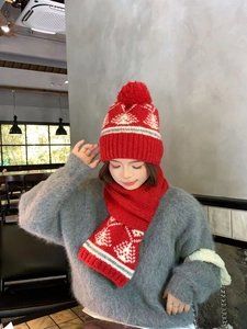 Dettaglio del berretto in maglia Fair Isle rossa con pompon e sciarpa coordinata invernale