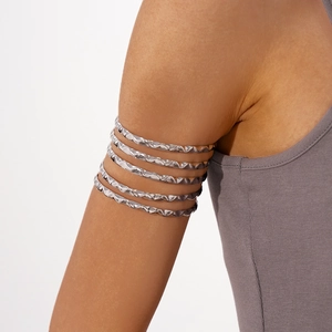 Close-up of bohemian silver multi-layer upper arm cuff featuring hammered metal textures