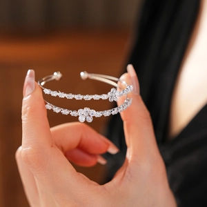 Détail d'un bracelet jonc argenté double couche avec fleurs en zircon et pierres marquise