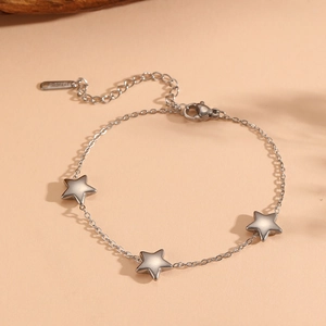 Detailed macro view of silver star charms on a stainless steel chain with lobster clasp