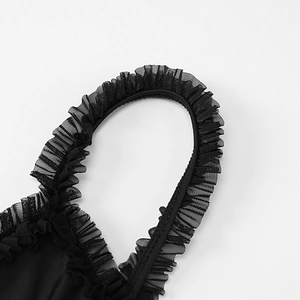 Vista dettagliata dell'abito nero con delicato tulle a rete e bordo plissettato