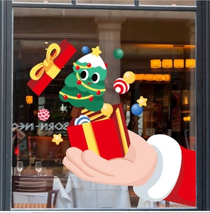 Detail of Christmas window stickers with red gift boxes and green trees on glass
