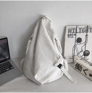 Detail of white washed canvas backpack with adjustable straps and plastic buckle