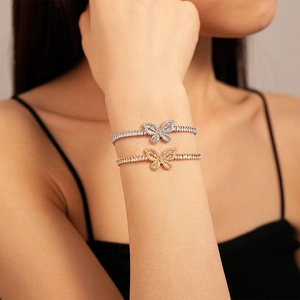 Dettaglio del bracciale tennis con farfalla e zirconi scintillanti indossato dal modello