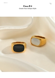 Elegant gold plated stainless steel rings with black and white oval inlays on white silk