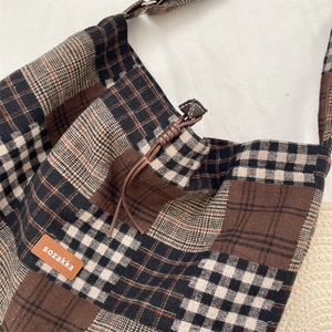 Dettaglio della borsa tote vintage a quadri con tessuto testurizzato e patch in pelle