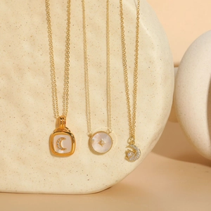 Detailed shot of celestial gold necklaces featuring shell crescent and star pendants