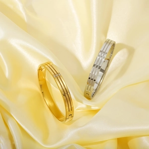 Minimalist gold and silver stainless steel bangles with three small diamonds on silk