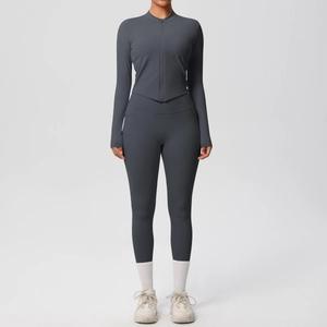 Détail de l'ensemble de fitness gris foncé avec ourlet en V et veste de sport à zip