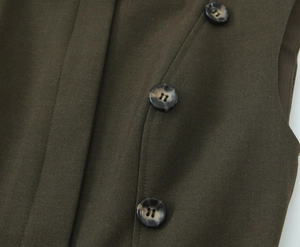 Détail du tissu sergé vert olive foncé avec trois boutons en résine tortue