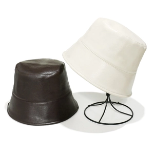 Minimalist PU leather bucket hats in brown and beige displayed on a white background