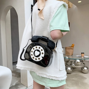 Detailed view of creative vintage telephone crossbody bag in high-gloss patent leather