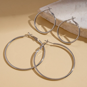Minimalist silver geometric hollow hoop earrings in two sizes on stone display