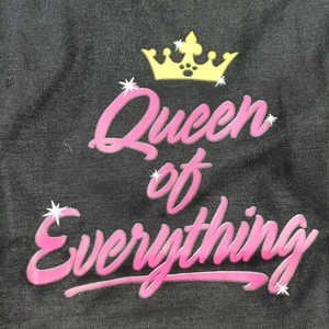Macro shot of pink Queen of Everything crown print on dark gray knit dog t-shirt