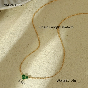 Detail shot of golden clover pendant with green gemstone and chain length specifications