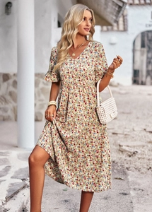 Close-up of beige V-neck floral dress with ruffle details and white handbag accessory