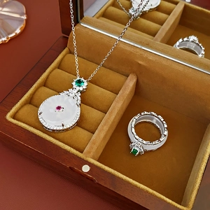 Macro shot of zircon inlaid round jade jewelry set in a red wood gift box