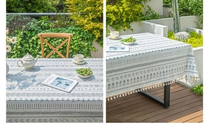 Detail of bohemian linen tablecloth with black geometric patterns and fringe tassels