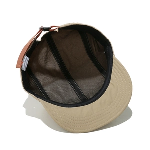 Internal details of khaki camping cap with breathable mesh and orange adjustable strap