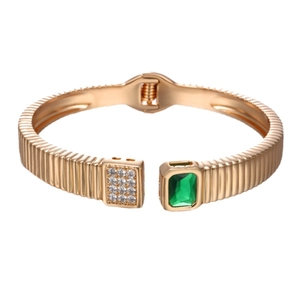 Luxurious gold open bracelet with emerald green square stone and micro-paved diamonds