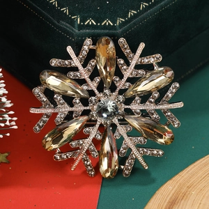 Macro shot of a golden snowflake brooch with crystals on green velvet jewelry case