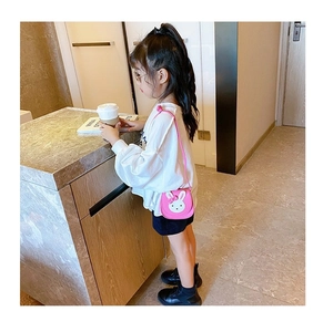 Detailed view of pink rabbit crossbody bag worn by a young girl in a modern setting