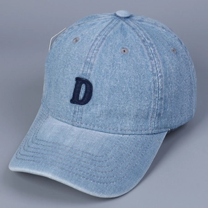 Close-up of embroidered blue letter D on washed denim baseball cap with retro texture