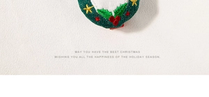Close-up of Christmas holly embroidery on hair clip with holiday greeting text
