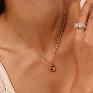 Gold chain necklace with round city pendant and pave crystal ring set on a model