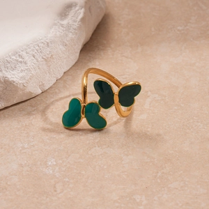 Close-up of golden open ring featuring detailed green enamel double butterfly charms