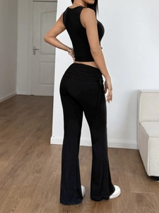 Vue arrière du haut court sans manches noir et du pantalon évasé pour un look sport
