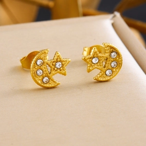 Detailed shot of gold moon and star stud earrings with inlaid sparkling crystals