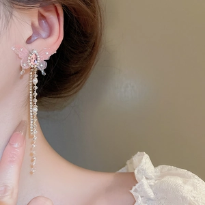 Macro detail of long tassel earrings with pink resin butterflies and shimmering pearls