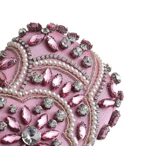 Close-up of pink satin evening bag with intricate rhinestone and pearl bead embroidery