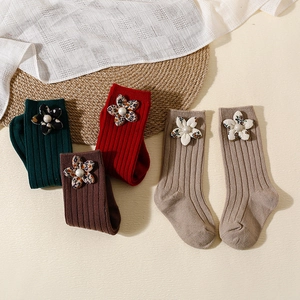 Floral knit baby socks with pearls and fabric flowers in festive red and green colors