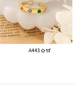Detailed macro view of an adjustable gold-plated ring set with colorful round gemstones
