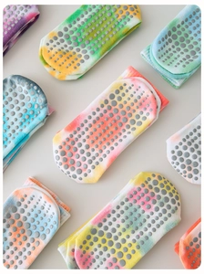 Detailed view of colorful tie-dye pilates socks with anti-slip rubber dots on the soles