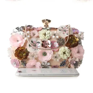 Detailed close-up of floral evening bag with sequins, pearls, and size reference