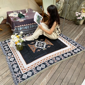 Bohemian geometric camping blanket with fringes shown in an outdoor glamping setup