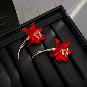 Macro detail of red lily brooches with matte finish and sparkling zircon stones