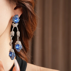 Detail of vintage flower tassel earring with blue gemstones and sparkling crystals