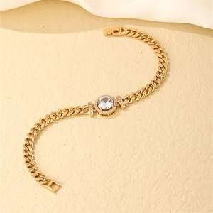 Close-up of golden Cuban link bracelet with a circular zircon centerpiece and clasp