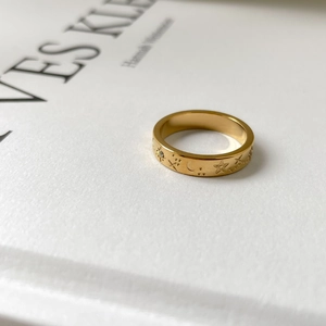 Detailed close-up of golden celestial ring with engraved star and moon patterns