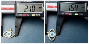 Detailed measurement of golden evil eye charm showing 21.0mm width and 15.4mm height