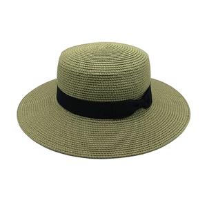 Detail of olive green flat top straw hat with wide brim and black ribbon bow accent