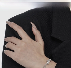 Detailed shot of silver minimalist bracelet featuring irregular pearls on a model wrist