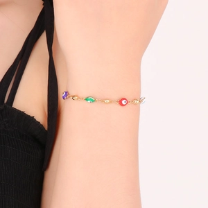 Detail of gold evil eye bracelet with colorful purple green red and white beads
