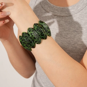 Close-up of green leopard print wide bangle bracelet with resin segments on wrist