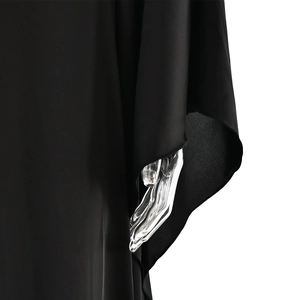 Detailed view of the wide batwing sleeve and smooth satin fabric on the black maxi dress